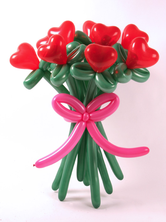  Делаем несколько цветков из воздушных шаров, чтобы плучился букет и вставляем их в "бантик", который мы сделали из розовых шаров для моделирования. Получаем букет из воздушных шаров.